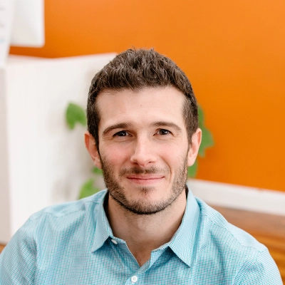 Pediatric Chiropractor Max Carlin Smiling In Blue Dress Shirt