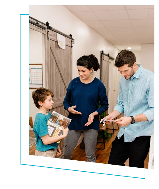 Pediatric Chiropractor Max Carlin And Staff Member Meeting With Young Patient