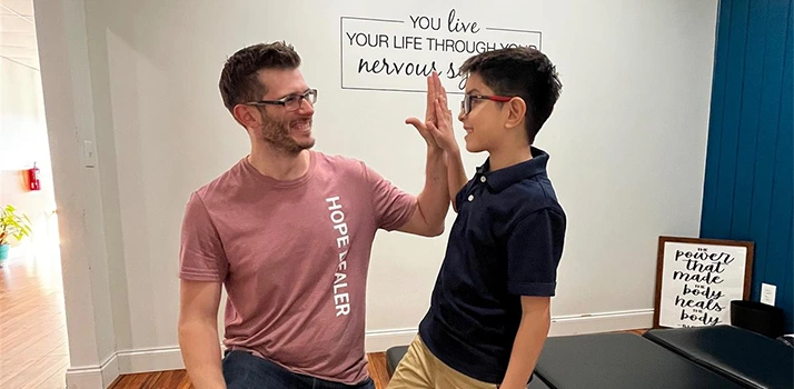 Pediatric Chiropractor Max Carlin High Fiving Patient Alec